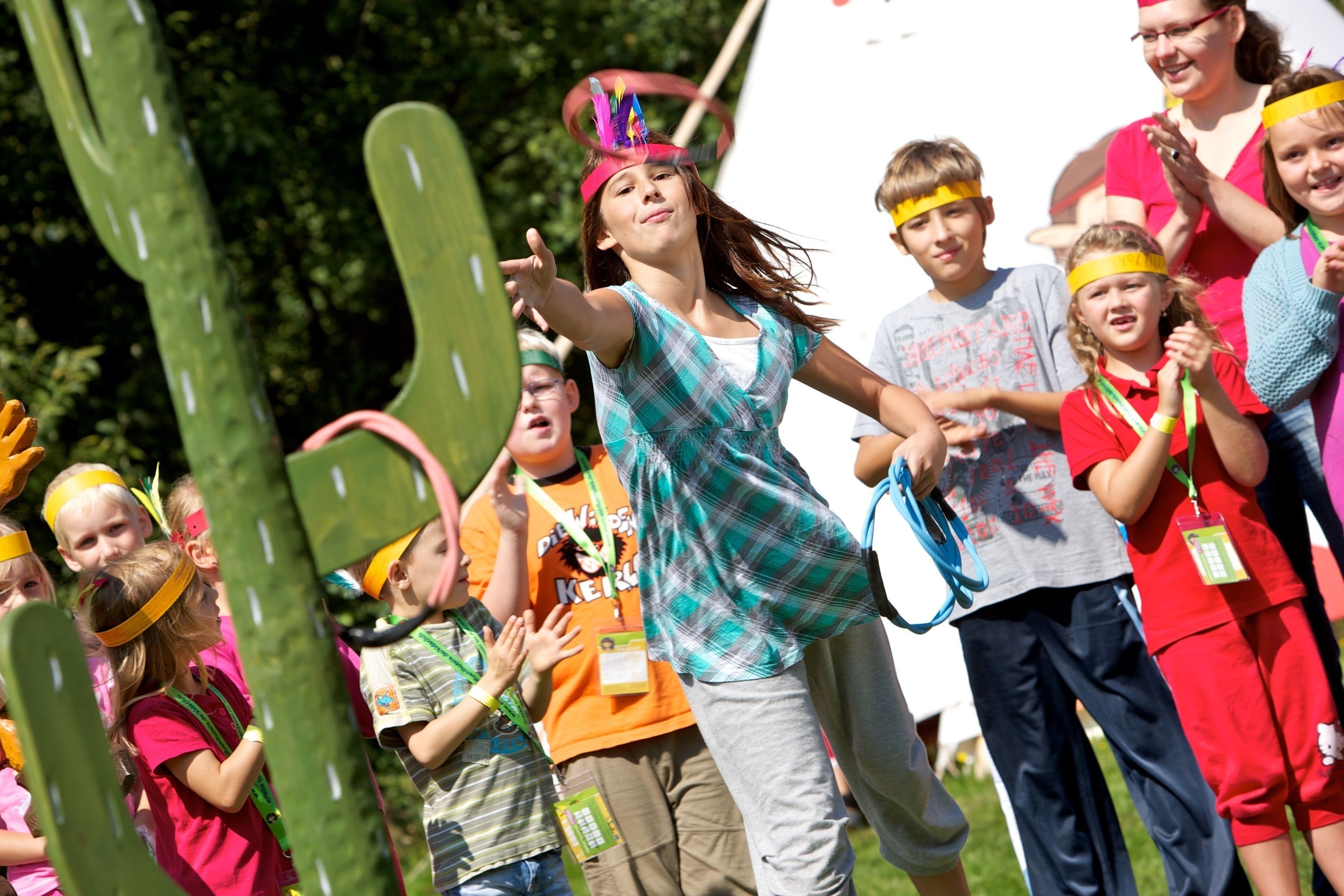 A group of people at an outdoor event with cacti in the background.
