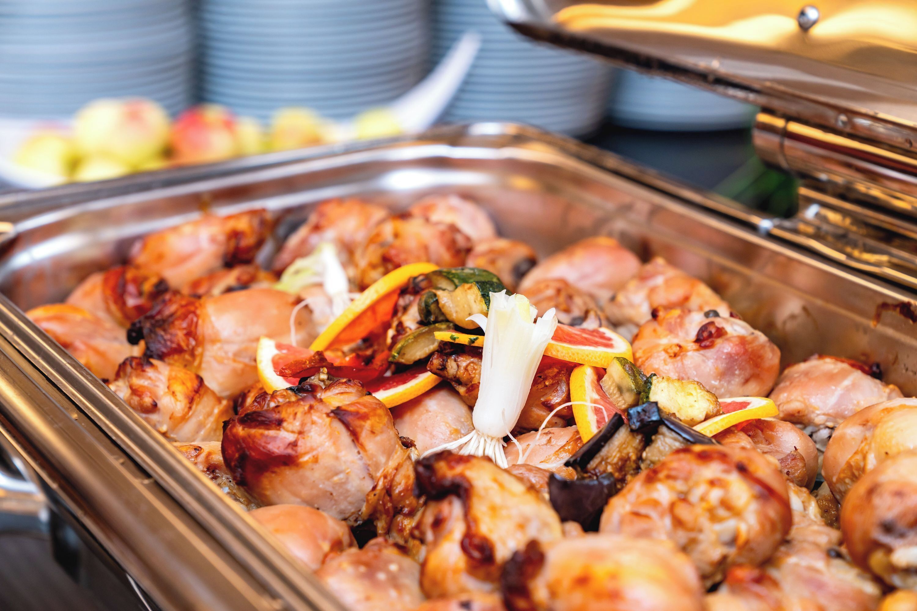 A buffet with various cooked meats and vegetables.