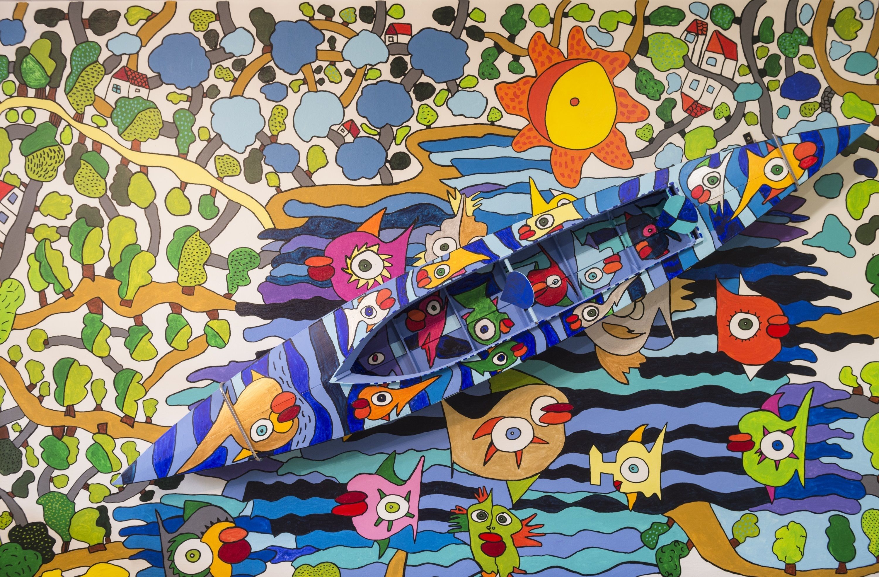 Un mural colorido con varios personajes fantásticos y un barco.
