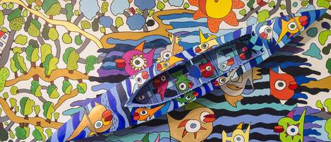 Un mural colorido con varios personajes fantásticos y un barco.