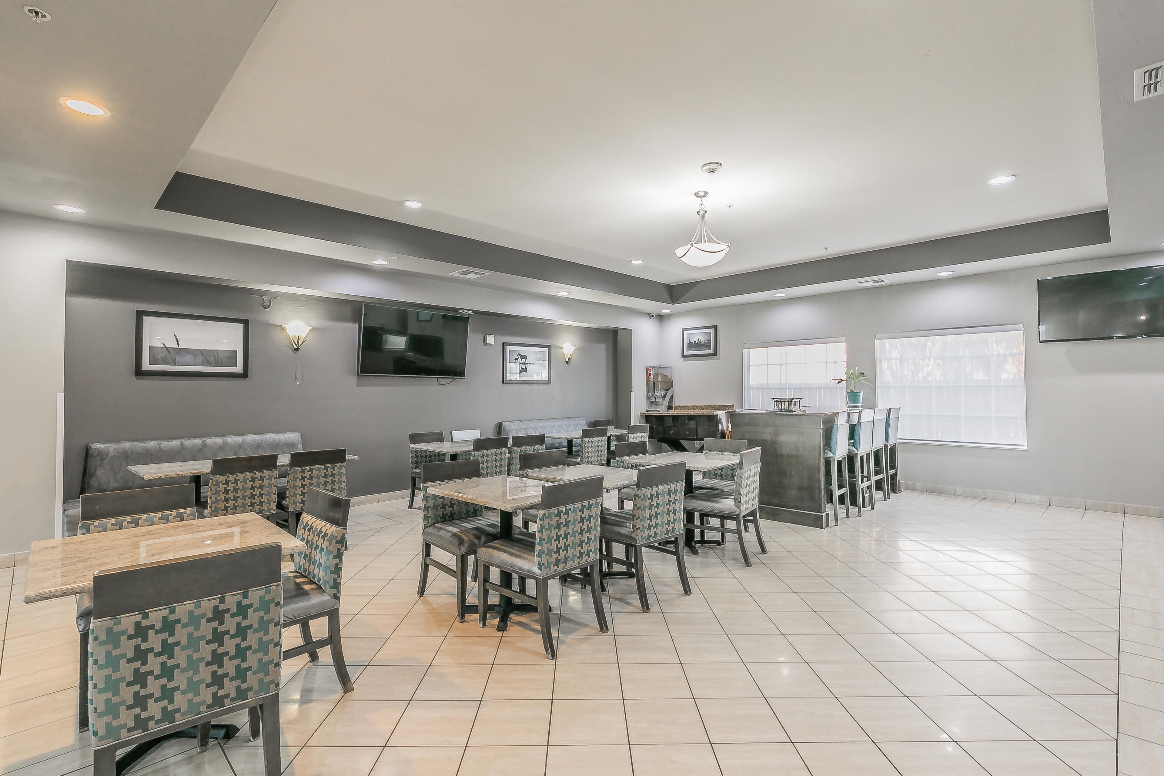 A spacious restaurant with high ceilings, recessed lighting, and a modern design.