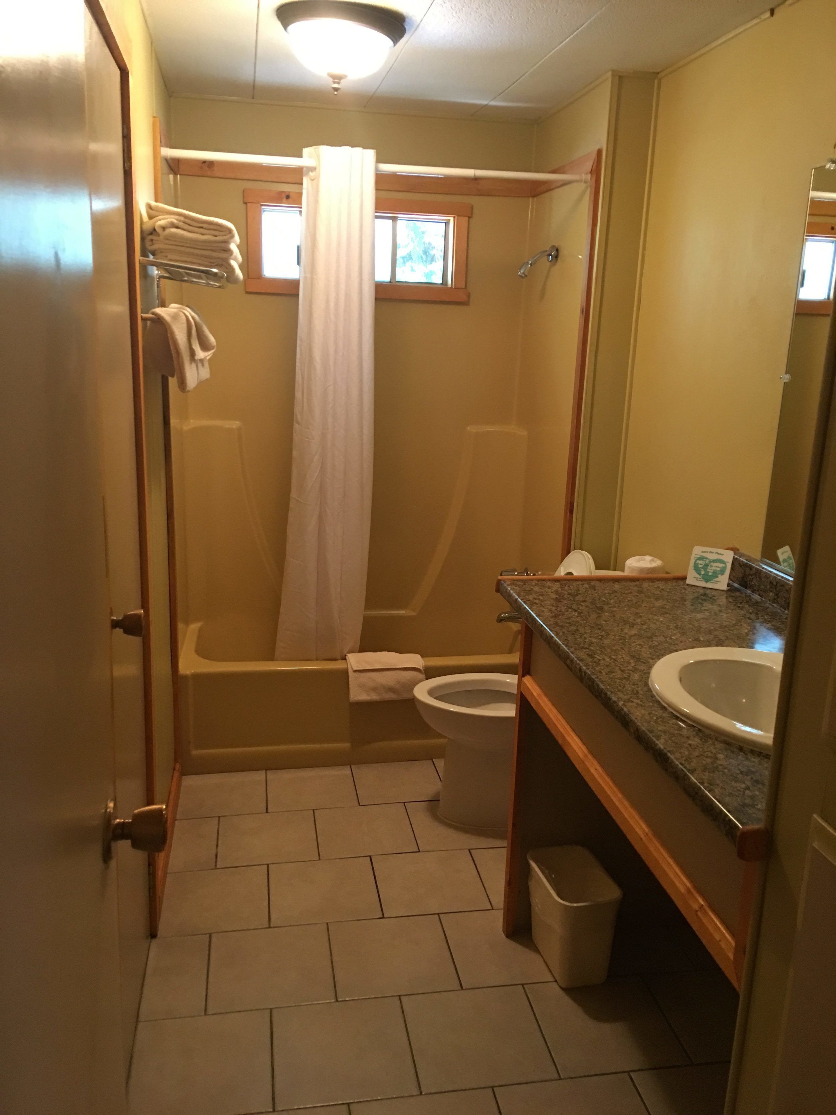 Un baño pequeño con bañera, inodoro y lavabo.