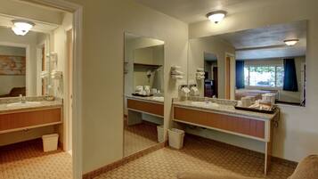 Un baño de hotel con dos lavamanos, un espejo grande y un perchero para toallas.