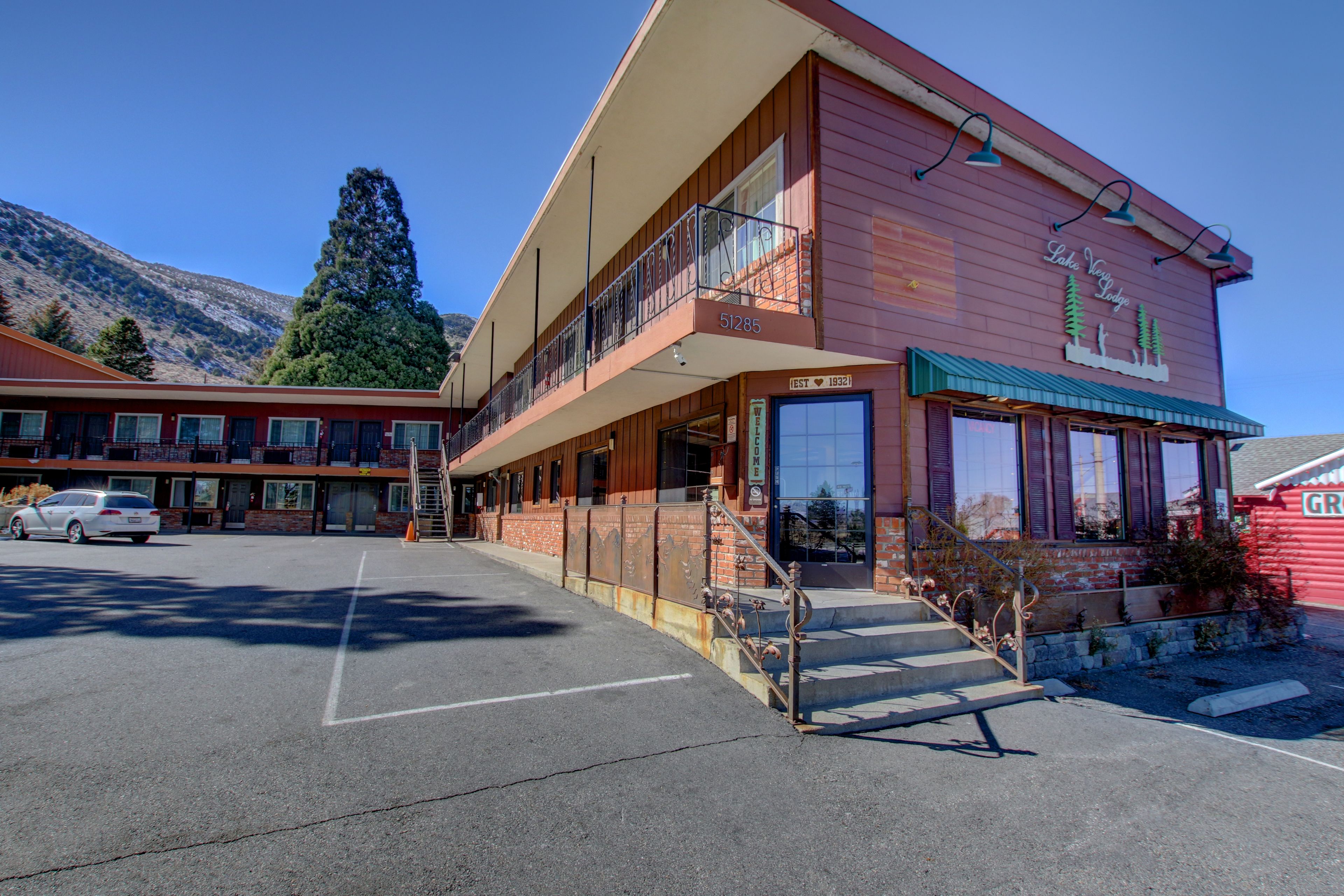 A two-story building with a red facade, a balcony on the upper floor, and a sign indicating it is a lodge.