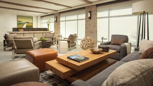 Un salon moderne avec un canapé, des fauteuils, une table basse et une cheminée.