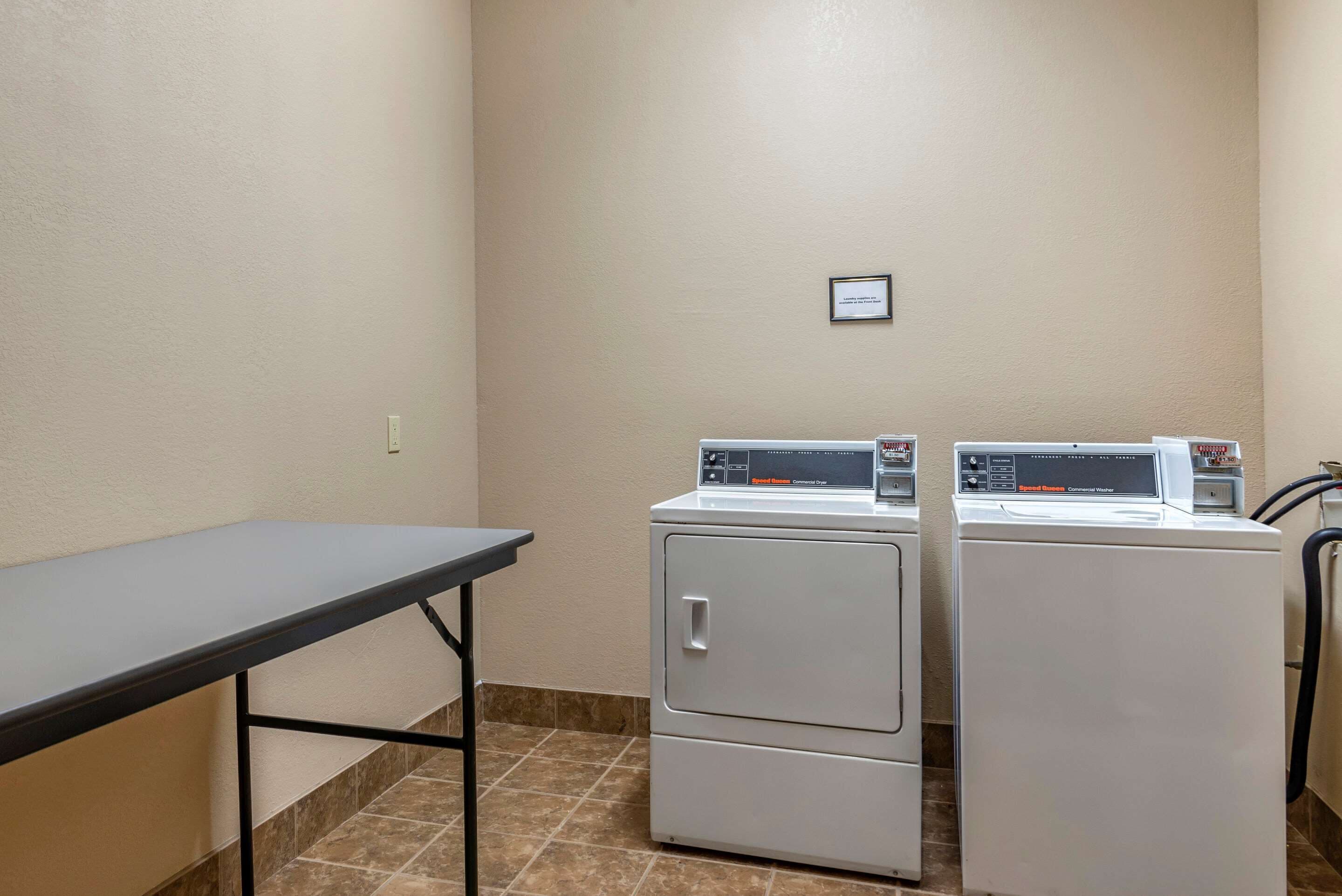 A laundry area with two front-loading washers and a table.