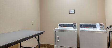 A laundry area with two front-loading washers and a table.