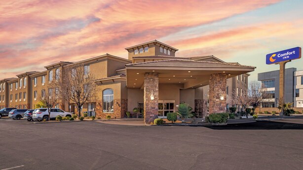 A Comfort Inn hotel with a brick facade, multiple windows, and a parking lot. - Comfort Inn at Convention Center (St. George)