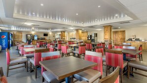 A spacious restaurant with multiple dining tables and booths, a kitchen area, and a Pepsi refrigerator. - Comfort Inn at Convention Center (St. George)