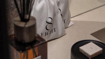 Una botella de perfume, una cajita y dos bolsas de cordón con el texto '& EIGHT'.