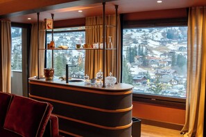 A hotel room with a large window offering a view of a snowy landscape. - Eight Cortina (Cortina d'Ampezzo)