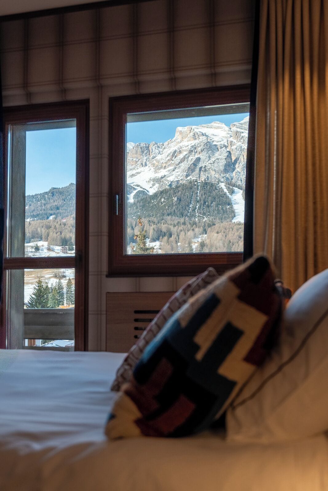 Habitación de hotel con cama y ventana que ofrece vistas a un paisaje montañoso.