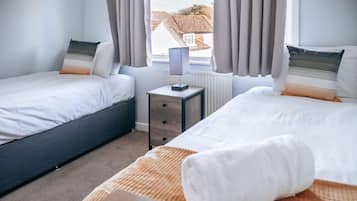 Tabla de planchar con plancha, cunas y ropa de cama