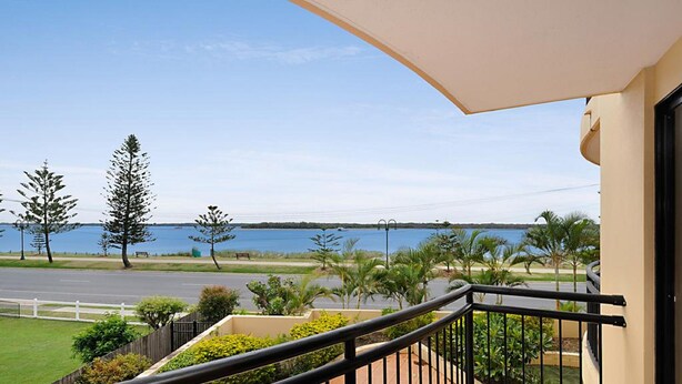 A balcony with a view of a road and a body of water. - Windsurfer Resort (Biggera Waters)
