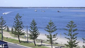 A coastal view with a beach, a road, and several boats on the water. - Windsurfer Resort (Biggera Waters)