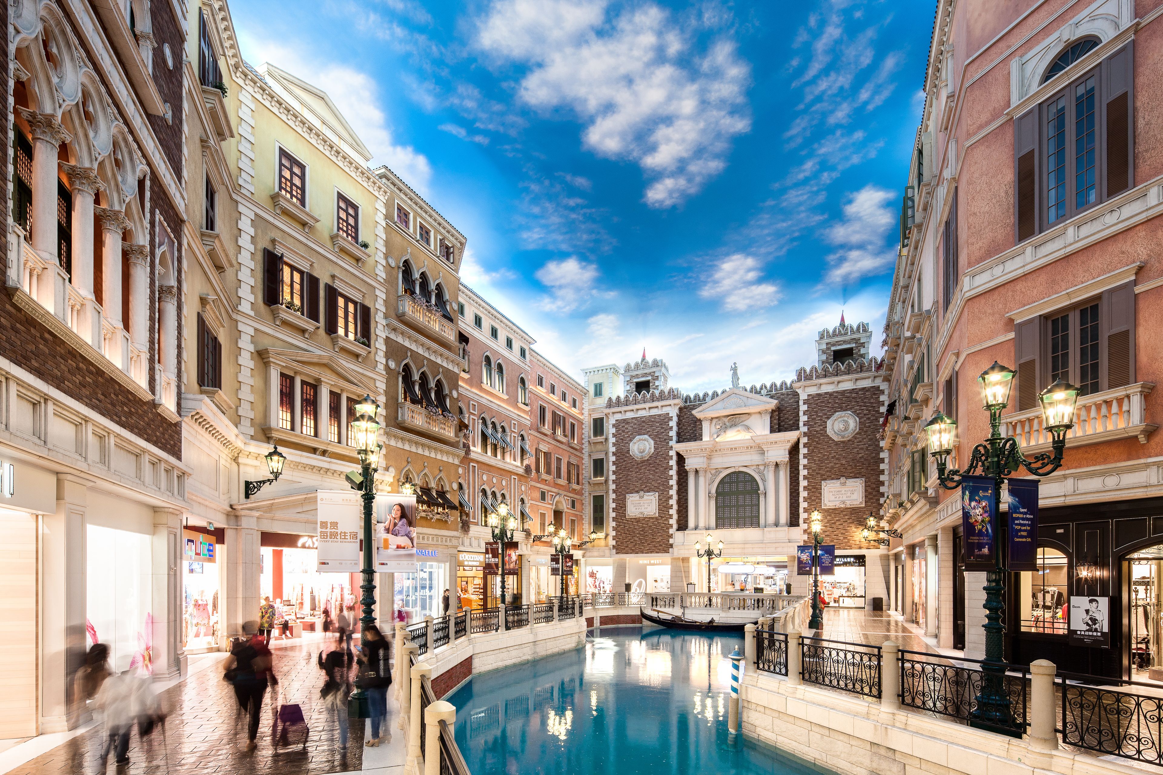 A historic Venetian-style building with a canal in the center, surrounded by shops and balconies.