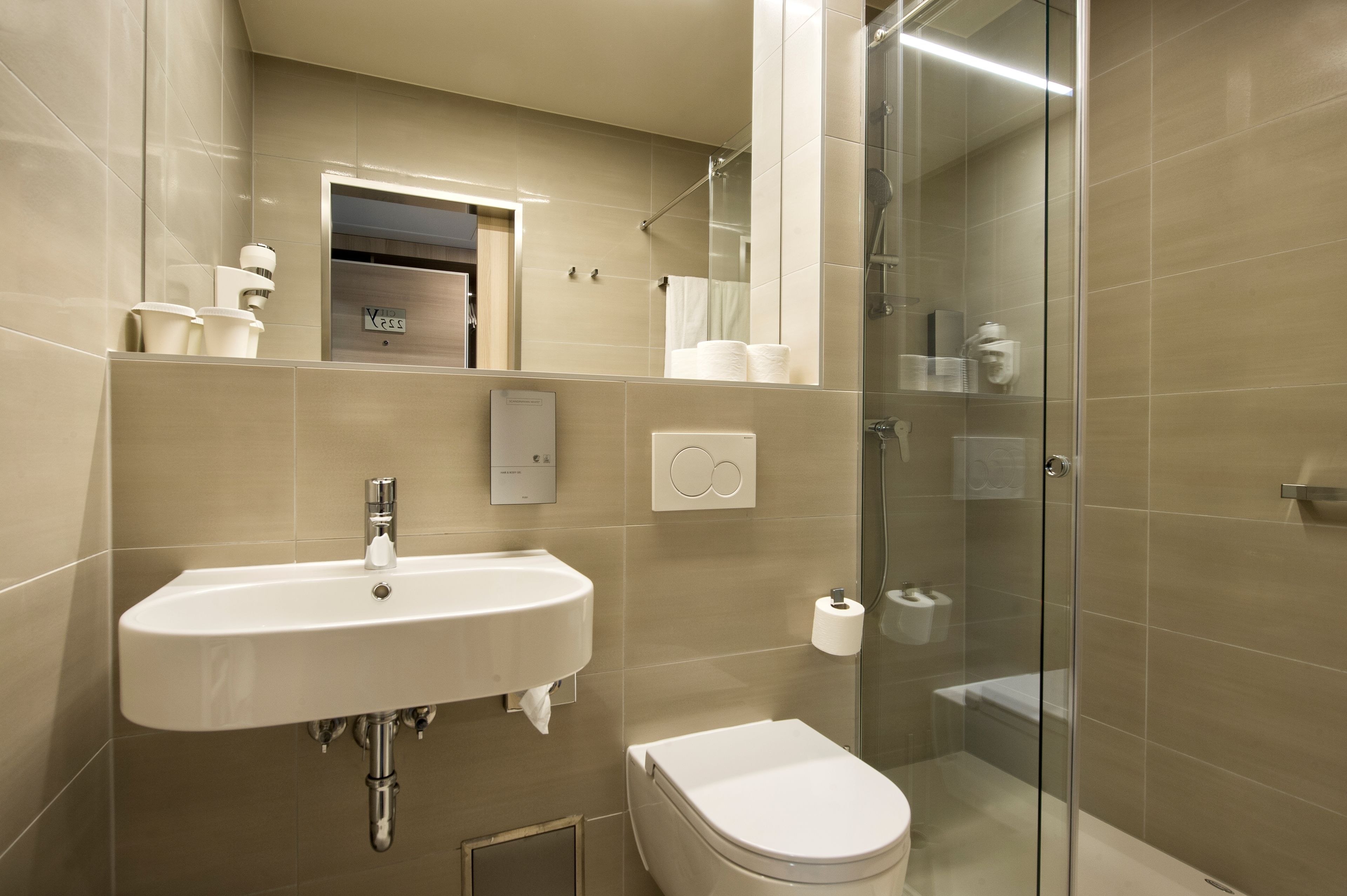 Une salle de bain moderne avec un lavabo, des toilettes et une douche à parois de verre.