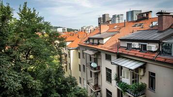 A multi-story building with red-tiled roofs, balconies, and air conditioning units.
