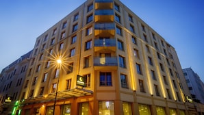 A multi-story hotel with a corner entrance, large windows, and a well-lit facade. - City Hotel Ljubljana (Ljubljana)
