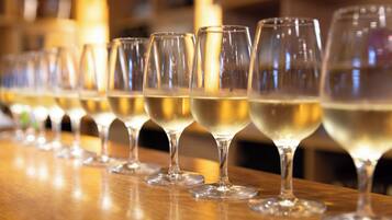 A row of empty wine glasses on a wooden bar counter.
