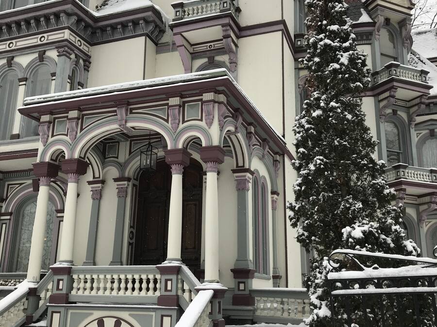 Ein prächtiges, historisches Gebäude mit aufwendiger Architektur, darunter ein großer Eingangsbereich mit Säulen und einer Treppe, die zu den Haupttüren führt.