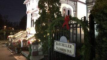 A gated entrance to Batcheller Mansion Inn with a sign.
