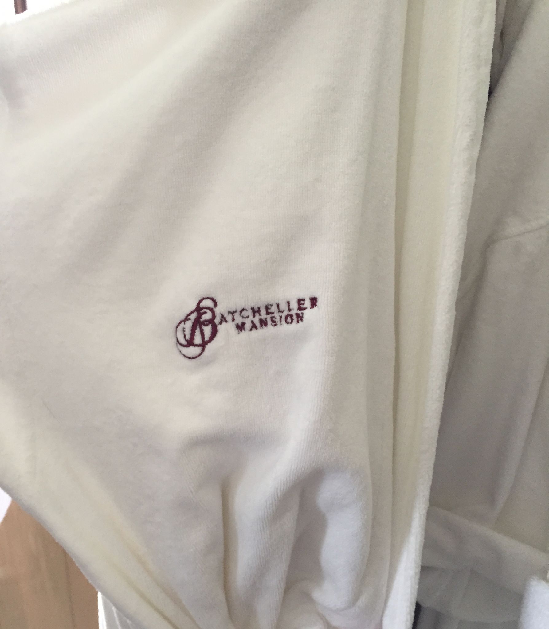 A white garment with a logo and text that reads "BATCHELLER MANSION".