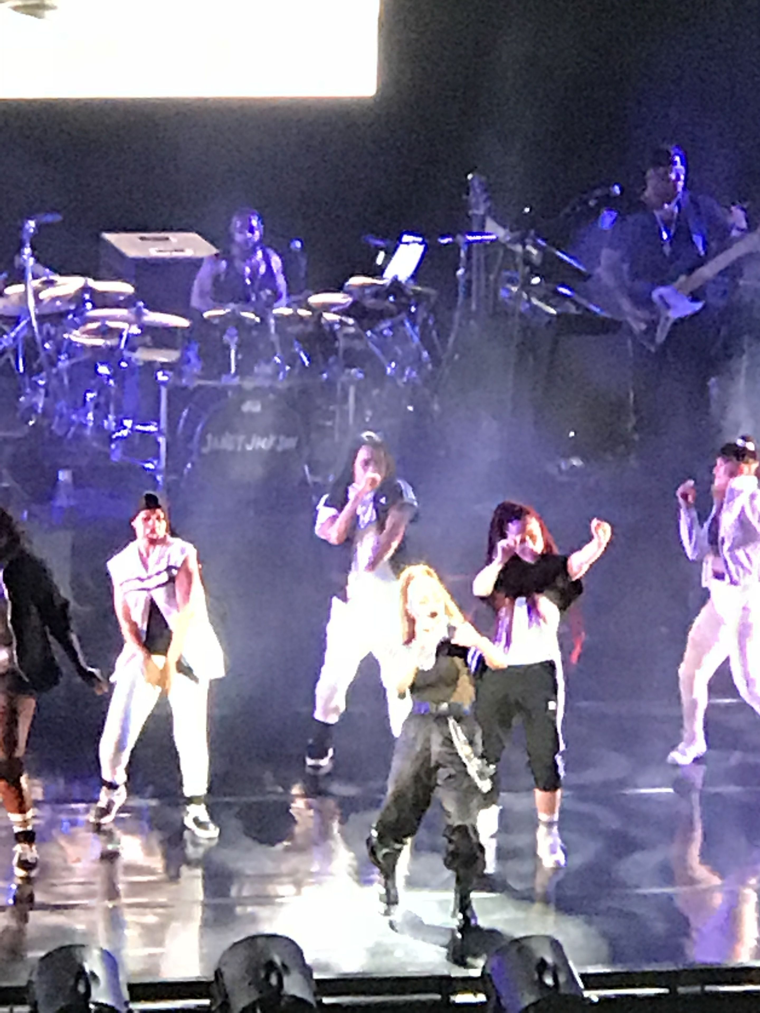 A stage with performers, a drum set, and a keyboard.