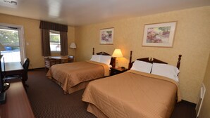 Une chambre d’hôtel avec deux lits, un bureau et une chaise.