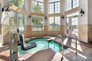 Un área de piscina con jacuzzi, ventanales y vistas al exterior.