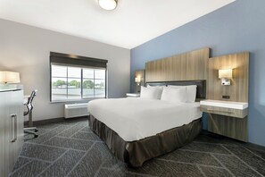 Hotelkamer met een groot bed, nachtkastjes, een bureau, een raam met uitzicht en een ingebouwde kachel.