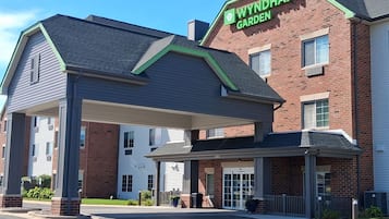 A Wyndham Garden hotel with a brick facade, a covered entrance, and a parking lot.