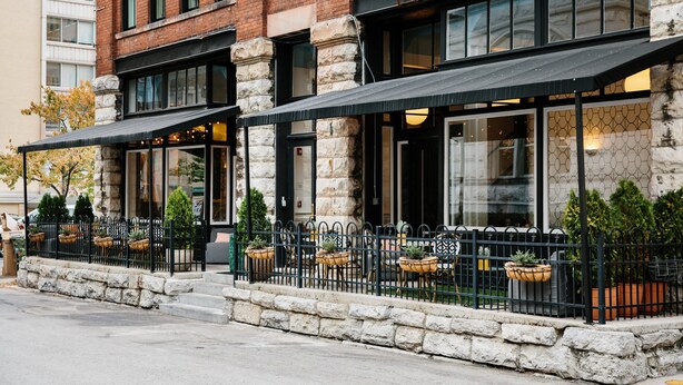 A brick building with large windows and outdoor seating. - The Dwell Hotel, a Member of Design Hotels (Chattanooga)