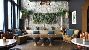 A cozy lounge area with a stone wall, a sofa set, and a coffee table. - The Dwell Hotel, a Member of Design Hotels (Chattanooga)