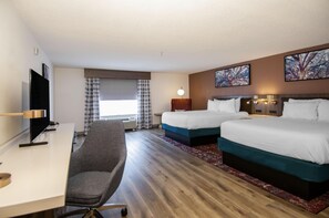 A hotel room with two beds, a desk with a chair, a flat-screen TV, and artwork on the walls. - Hilton Garden Inn Hattiesburg (Hattiesburg)