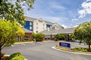 Un Hilton Garden Inn con estacionamiento y zonas verdes circundantes.