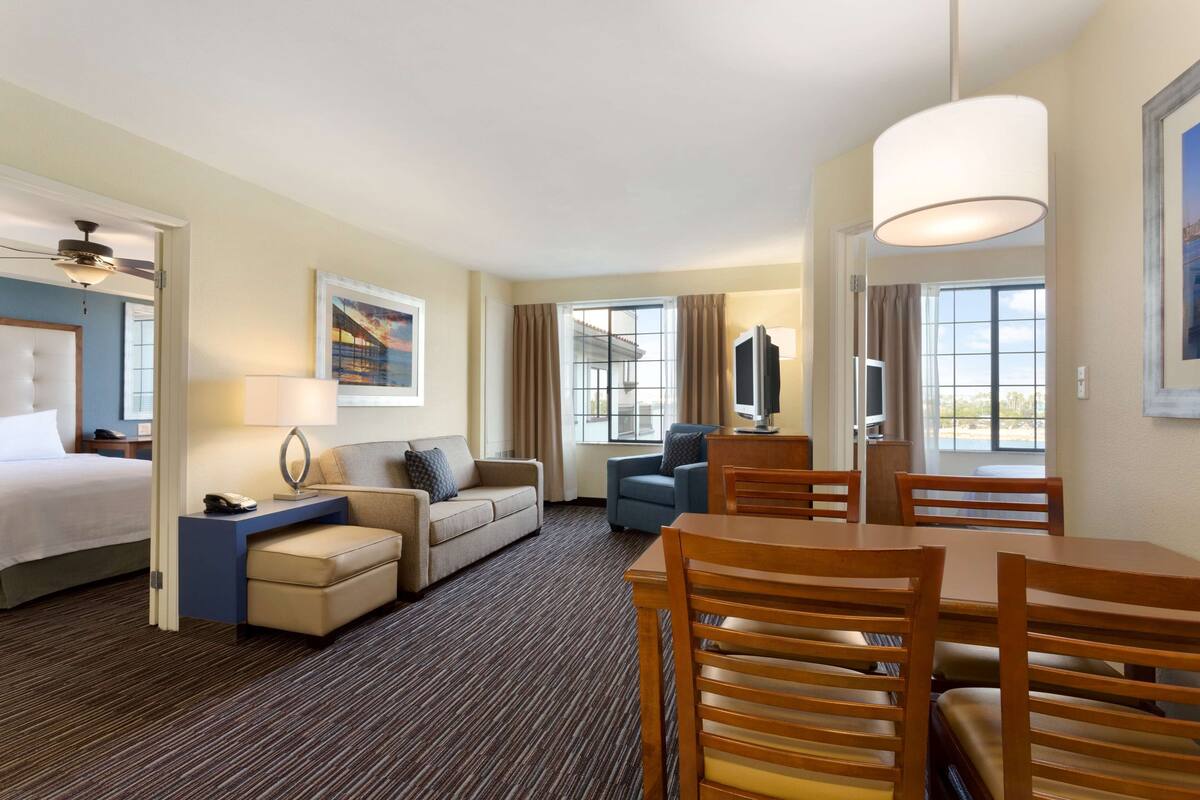 Une chambre d’hôtel équipée d’un lit, d’un canapé, d’un bureau, d’une chaise, d’une table et d’un téléviseur.