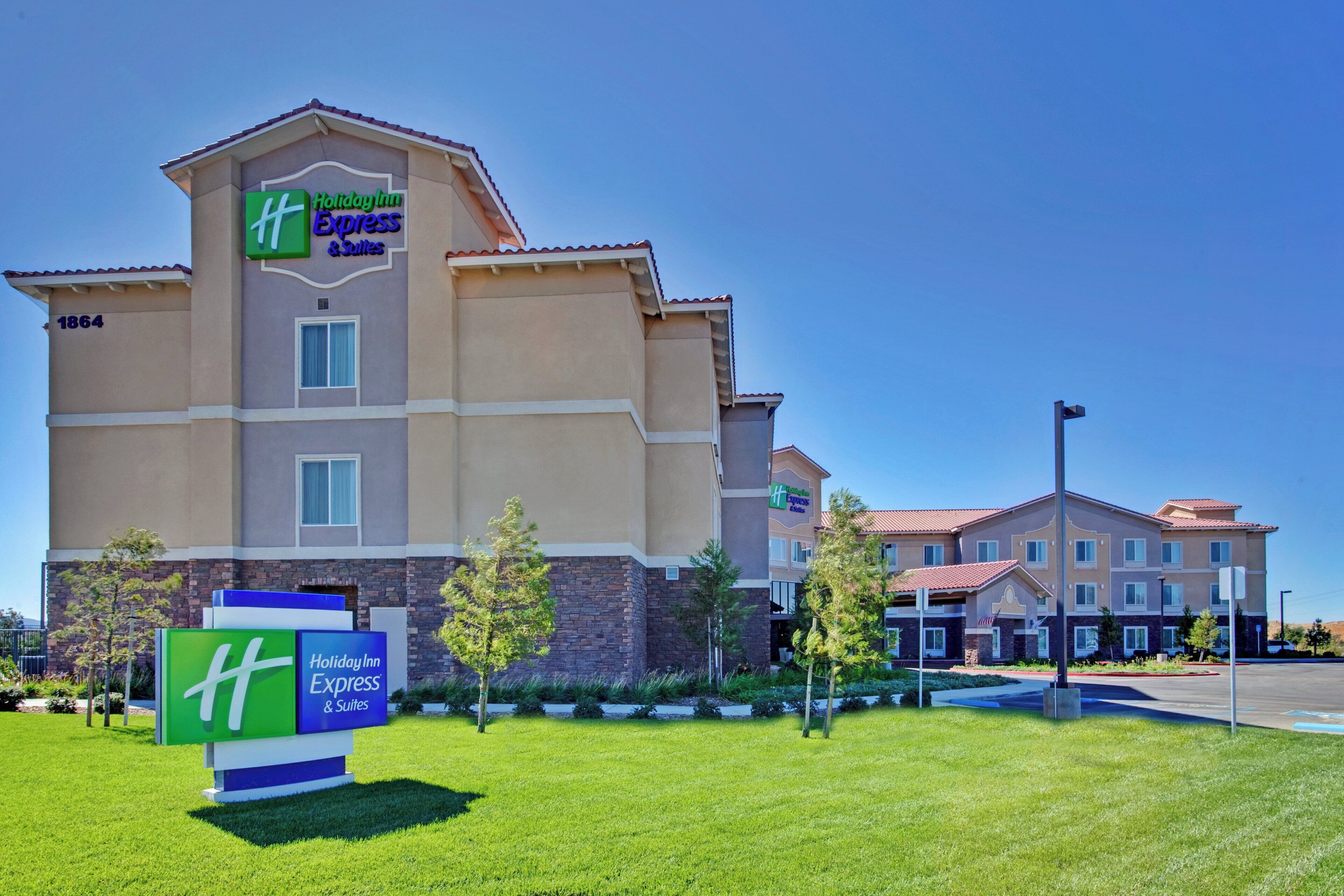 A Holiday Inn Express & Suites building with a clear blue sky.