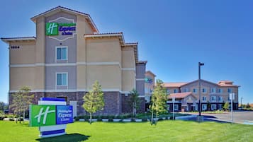A Holiday Inn Express & Suites building with a clear blue sky.