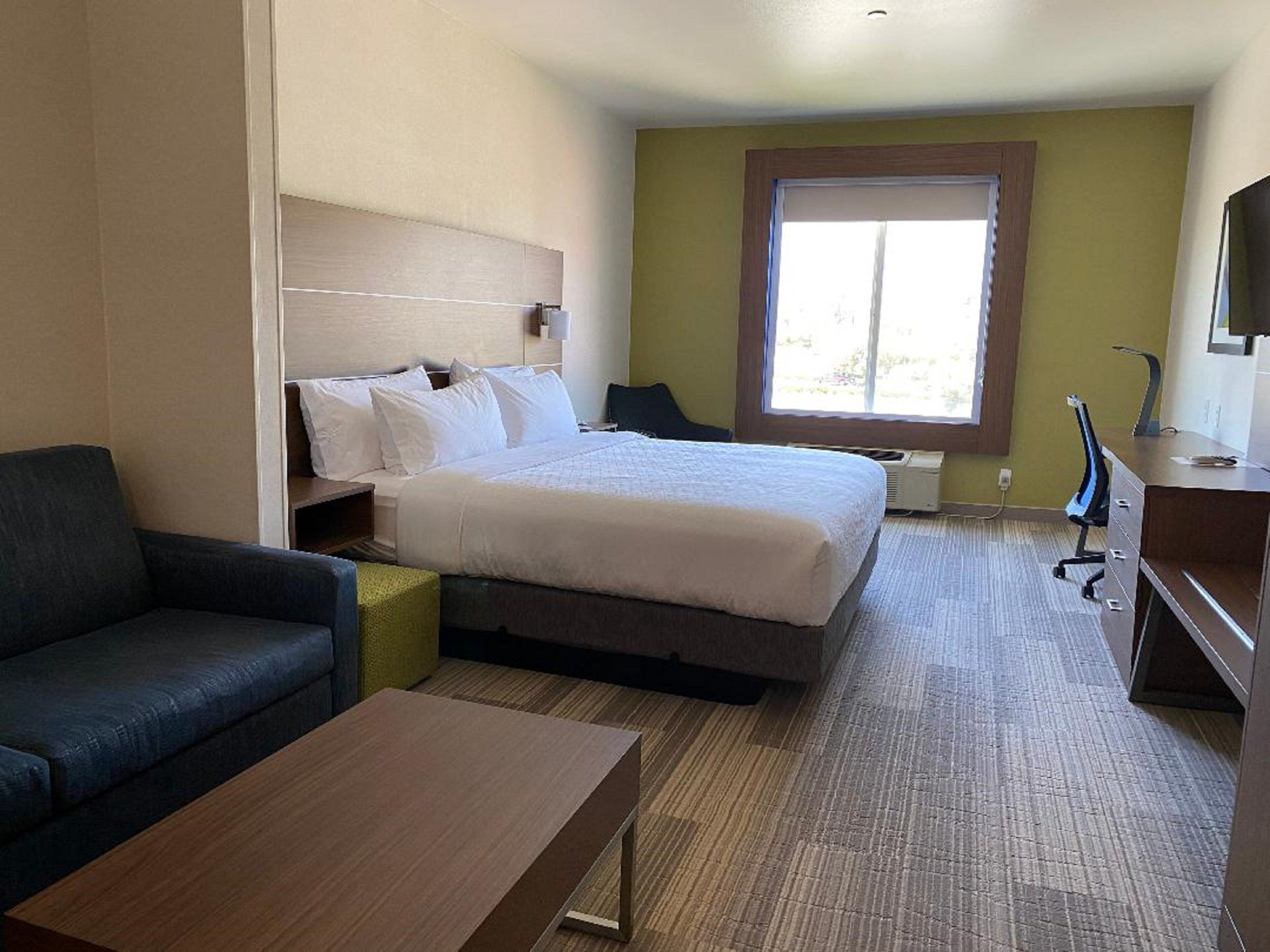 Ein Hotelzimmer mit Bett, Schreibtisch, Stuhl und einer Couch.