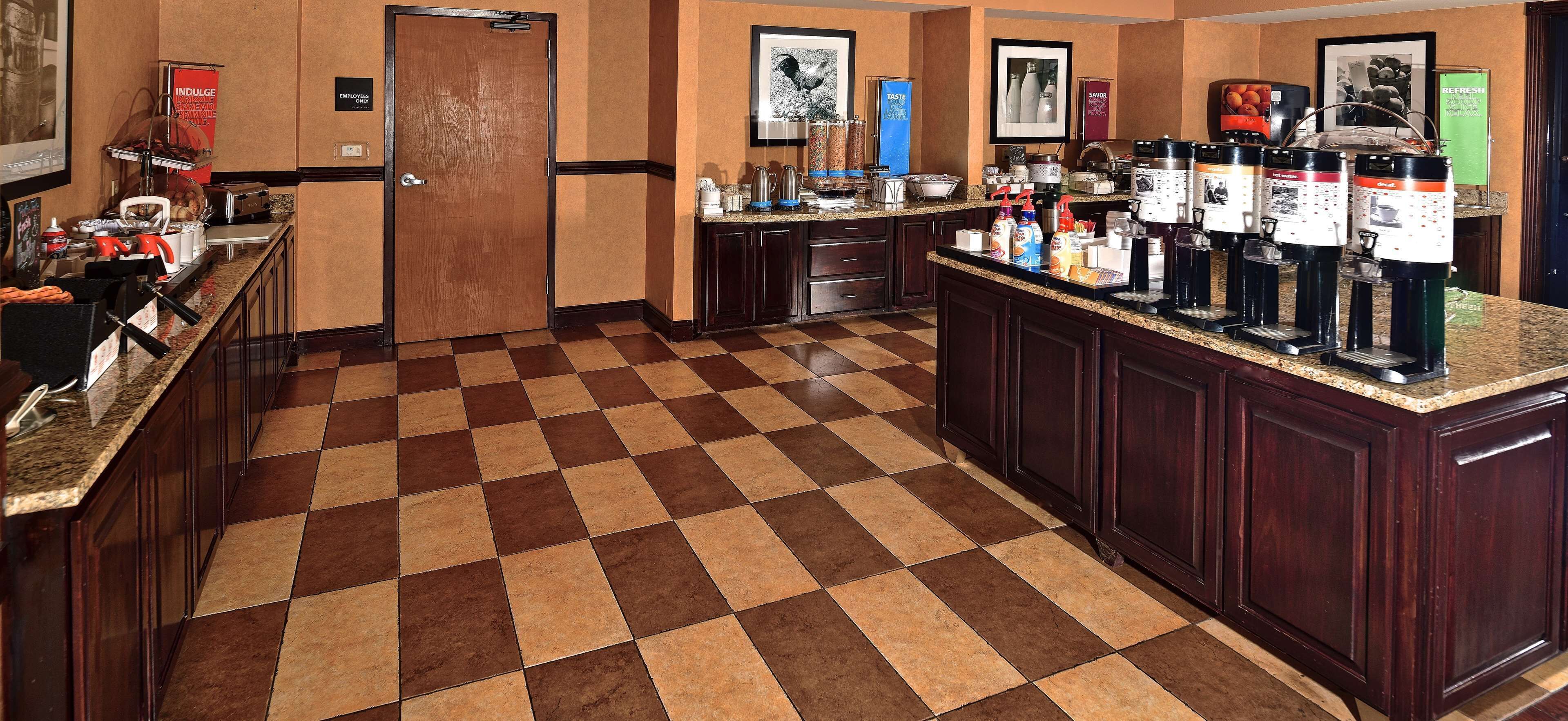 Eine Hotelhalle mit Schachbrettmuster, einer Kaffeestation und einem Empfangsbereich.