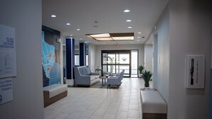 A modern lobby with a reception desk, seating area, and a large wall map.