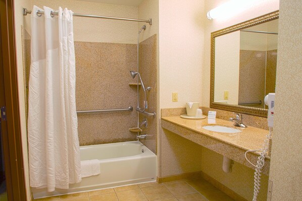 A bathroom with a bathtub, a shower, a sink, and a mirror.