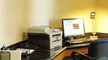 Une chambre d’hôtel équipée d’un bureau, d’une imprimante, d’un ordinateur et d’une chaise.