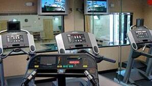 Une salle de sport équipée de tapis de course et d'appareils d'exercice.