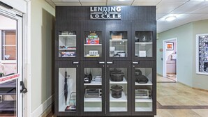 A lending locker with various items inside, including a chess checker set, a Connect 4 game, and a coffee maker.