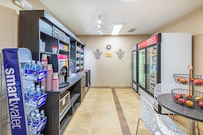 A kitchenette area with a refrigerator, a coffee machine, and a water dispenser.