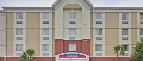 A multi-story hotel with a prominent entrance, a brick facade, and a sign for Candlewood Suites.