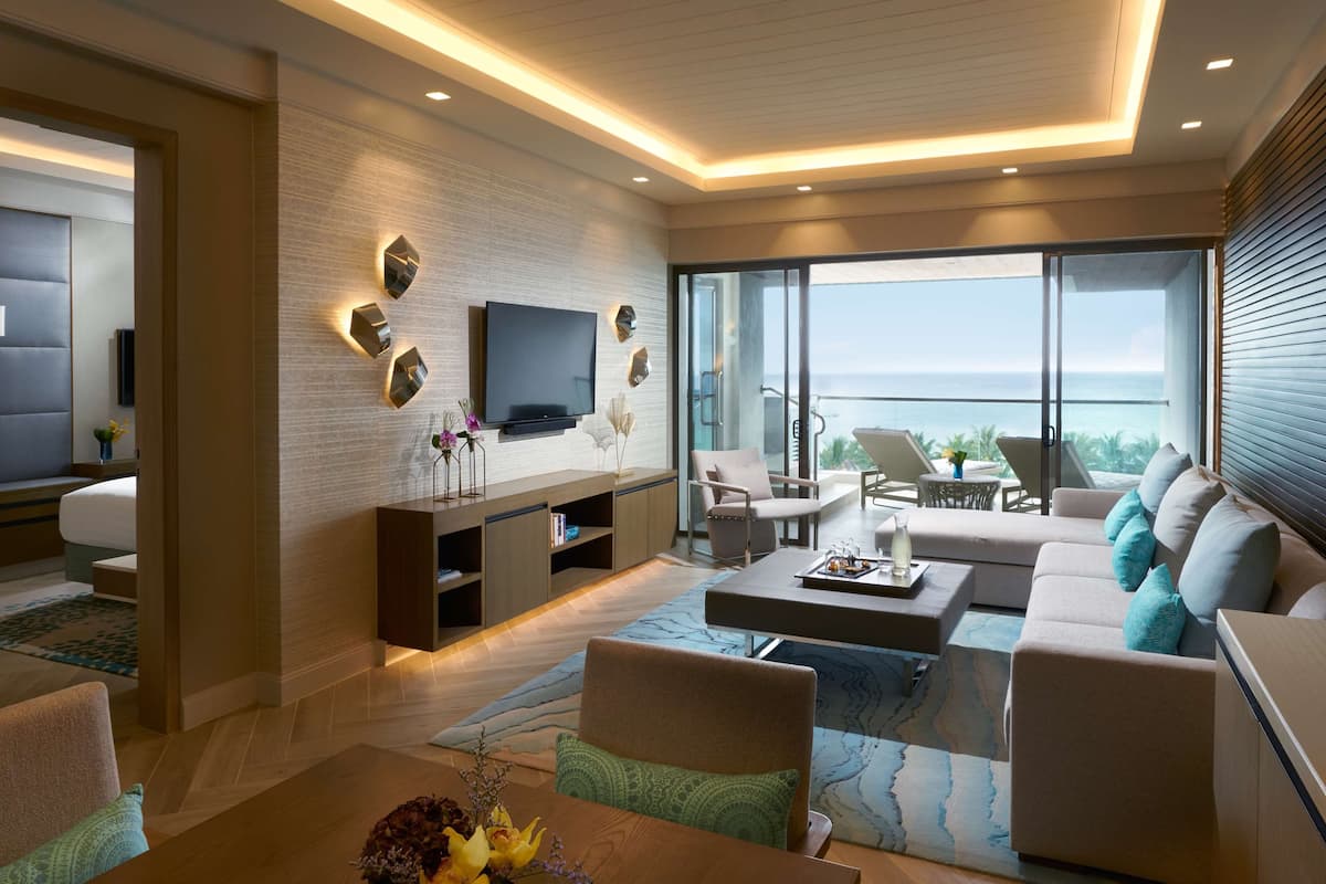 Un salon moderne doté d’un téléviseur, de sièges et d’un balcon offrant une vue agréable.