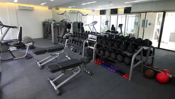 A gym with treadmills, weight machines, and a variety of dumbbells.